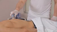 Orthopädiezentrum Wien - Mann erhält Stromtherapie im Rahmen einer Physikalischen und Elektrotherapie