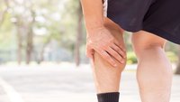 Orthopädiezentrum Wien - Eine Person greift sich an den Unterschenkel aufgrund von Beschwerden durch Polyneuropathie.