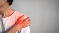Orthopädiezentrum Wien - Älterer Mann greift sich an die Schulter, möglicherweise aufgrund einer Frozen Shoulder.