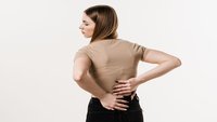 Orthopädiezentrum Wien - Beckenschiefstand und Beinlängendifferenz bei einer Person, die ihren unteren Rücken hält